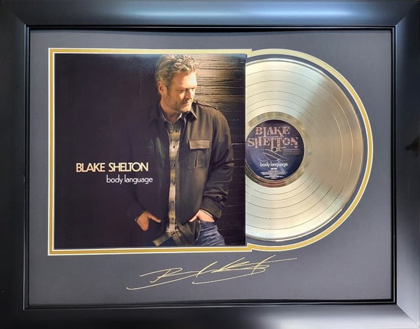 Framed gold record displayed beside the Blake Shelton album cover with a laser-reproduced signature, offered as a charity auction lot