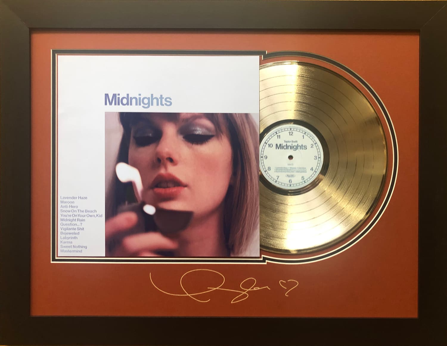 Framed gold record displayed beside the Taylor Swift Midnights album cover with a laser-reproduced signature, offered as a charity auction lot