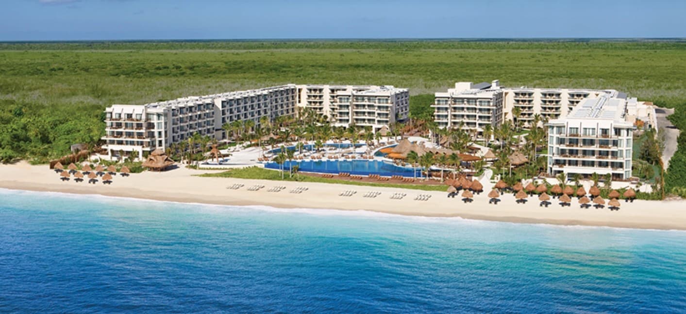 Beachfront luxury resort seen from the sea, representing the vacation packages available for charity auctions